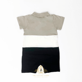 The back of a short-sleeve baby romper with a color-blocked design in taupe, white, and black, laid flat on a white background. A watermark logo for 'The Vintage Teddy' is visible at the bottom.