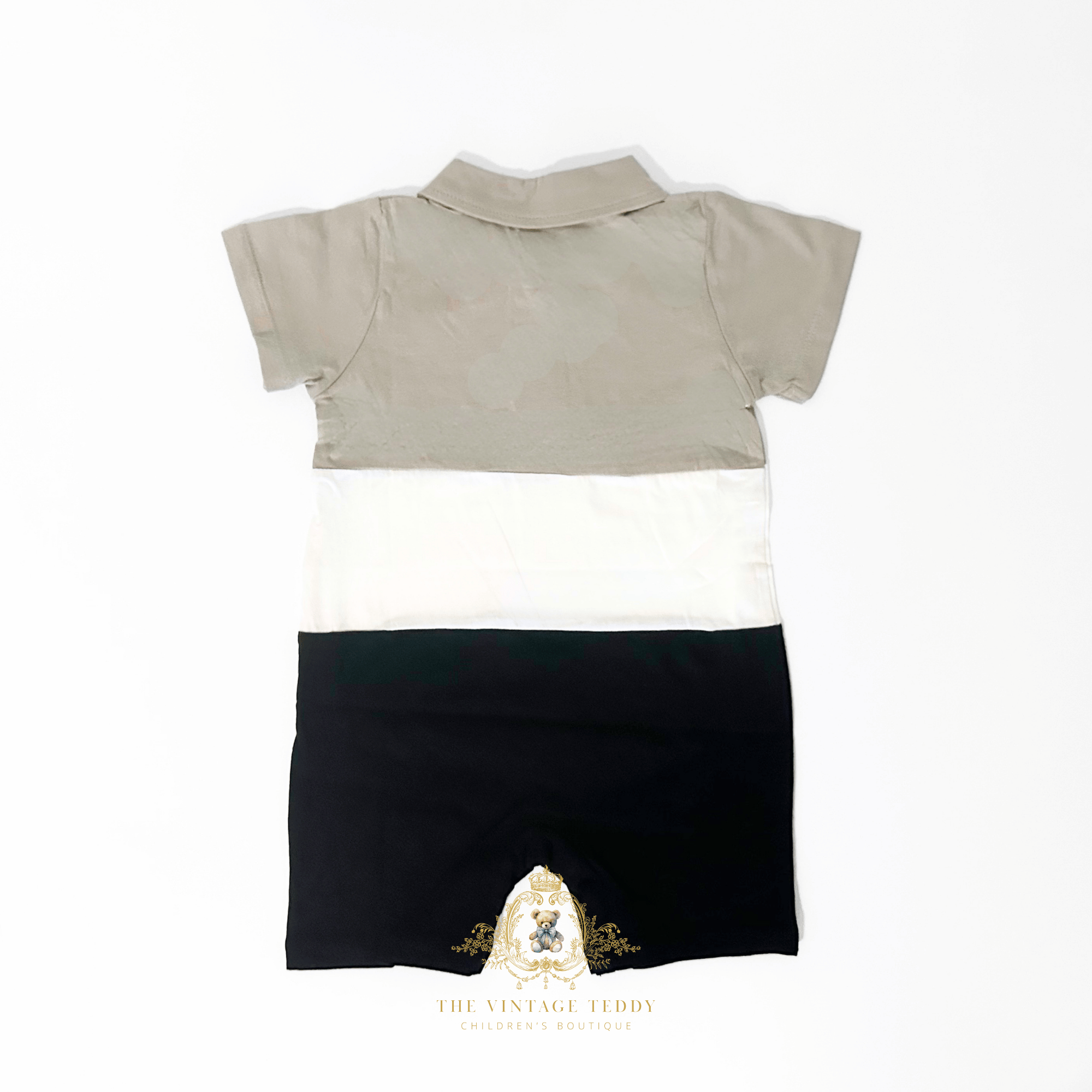 The back of a short-sleeve baby romper with a color-blocked design in taupe, white, and black, laid flat on a white background. A watermark logo for 'The Vintage Teddy' is visible at the bottom.