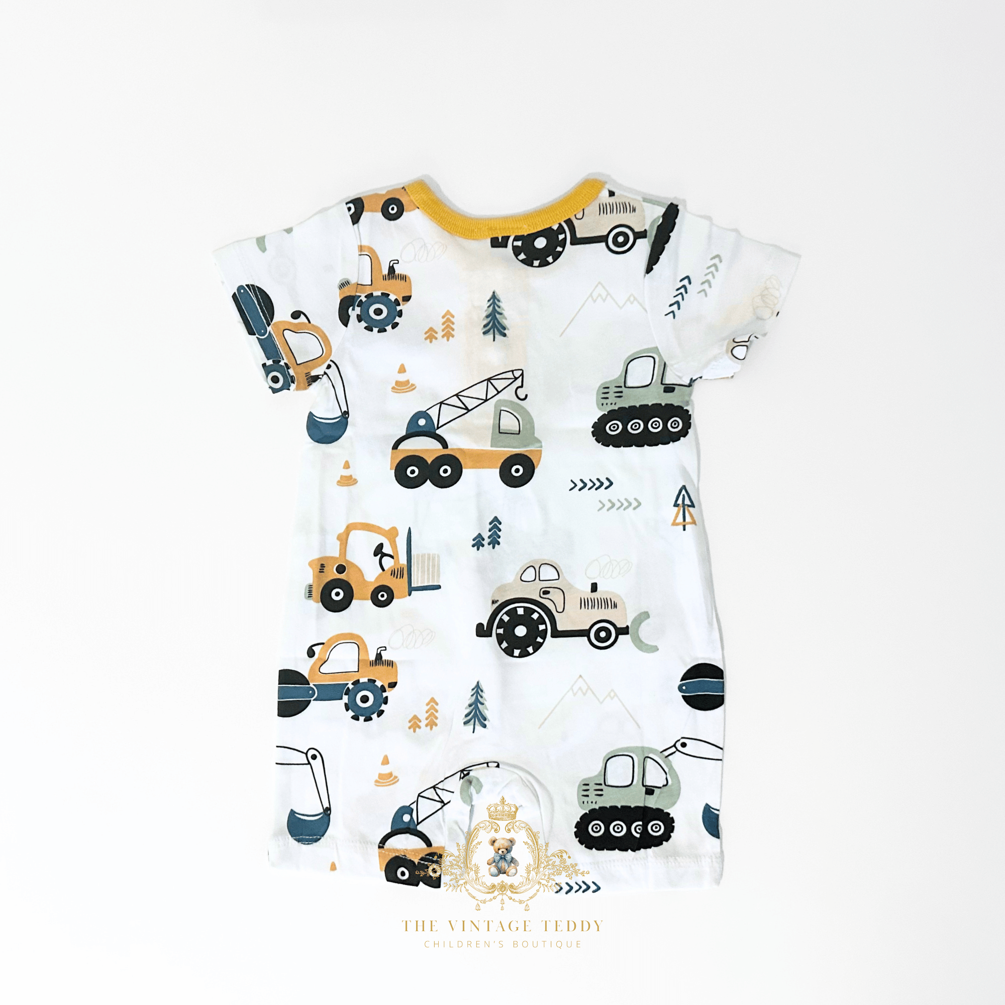 The back of a white short-sleeve baby one-piece with an all-over construction vehicle print, featuring yellow, green, and gray bulldozers, tractors, and excavators. The baby romper is laid flat on a clean white background with a The Vintage Teddy's  watermark at the bottom.