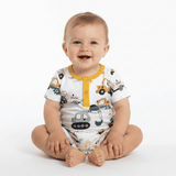A baby on a white studio background, wearing a white short-sleeve romper printed with construction vehicles and featuring a yellow collar and three yellow buttons.