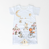 A white short-sleeve baby romper with a whimsical circus-themed watercolor print, featuring a crescent moon, balloons, tents, and animals. The brand logo 'The Vintage Teddy' is visible at the bottom.