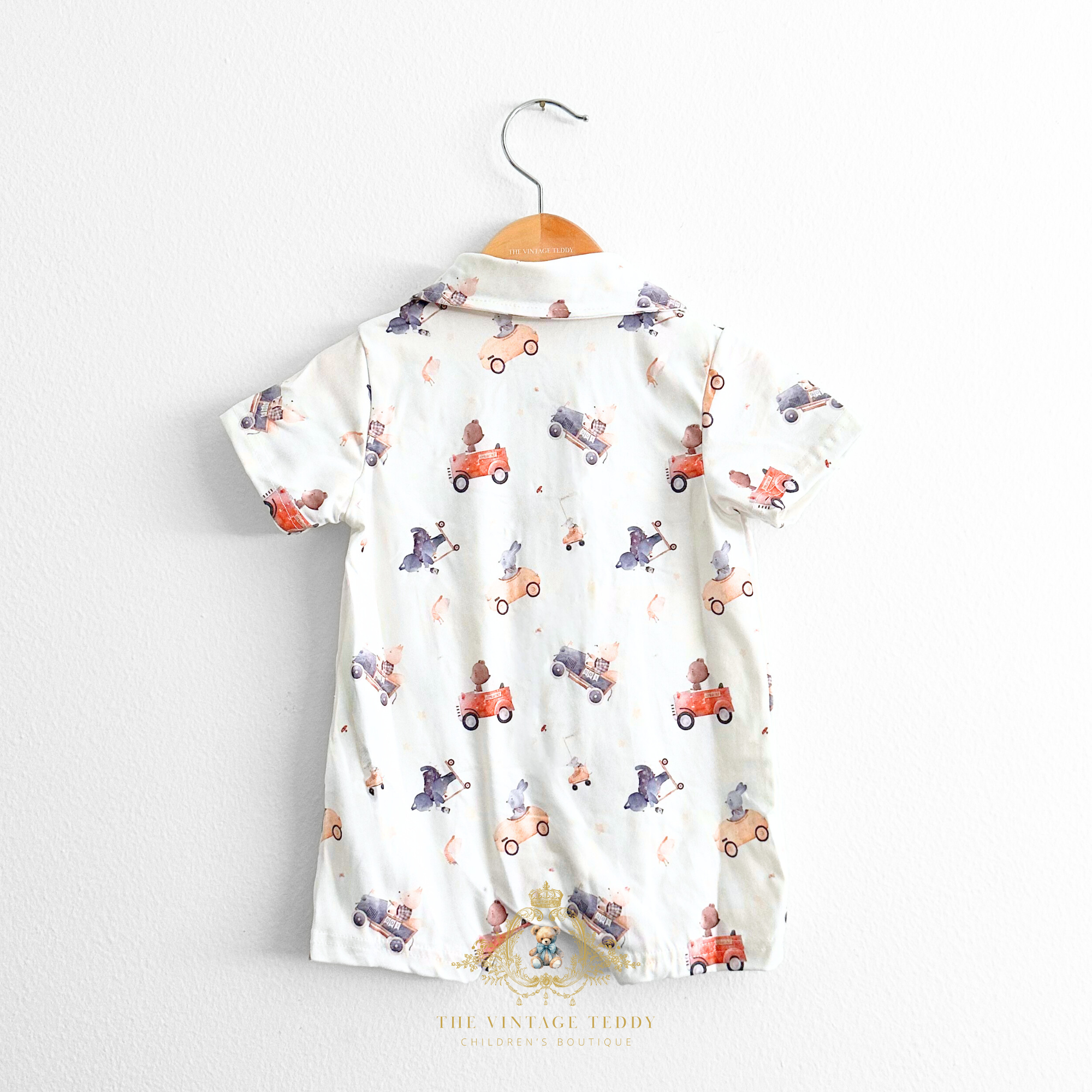 Baby romper shorts with cute colorful bears and friends in cars pattern fabric displayed on a hanger against a white background The Vintage Teddy Children's Boutique Cute Baby & Toddler Clothes