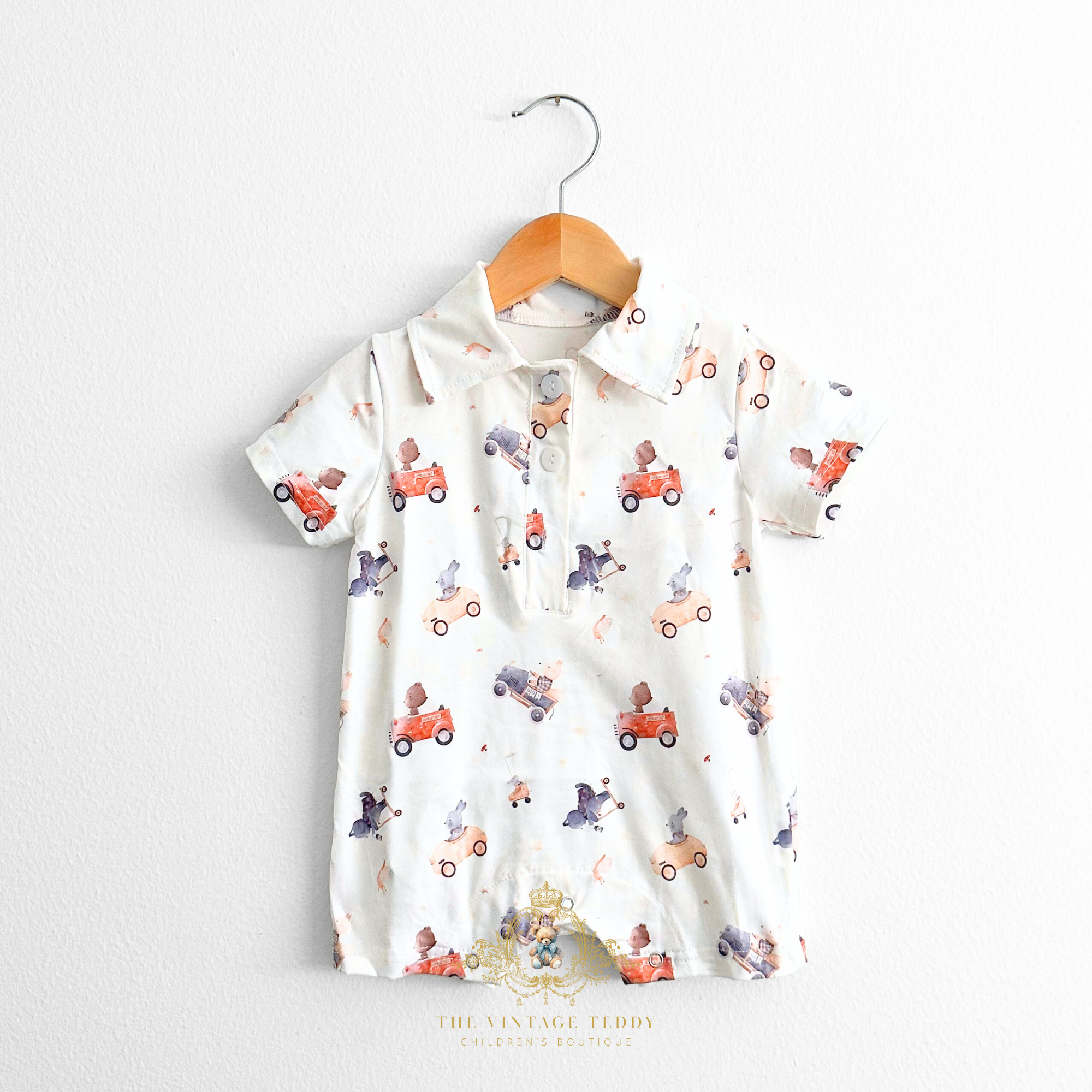 Baby boys romper with bears and animals driving vintage cars fabric pattern displayed on a hanger against a white background wall. Cute clothes for Baby & Toddlers from The Vintage Teddy's online kids shop.