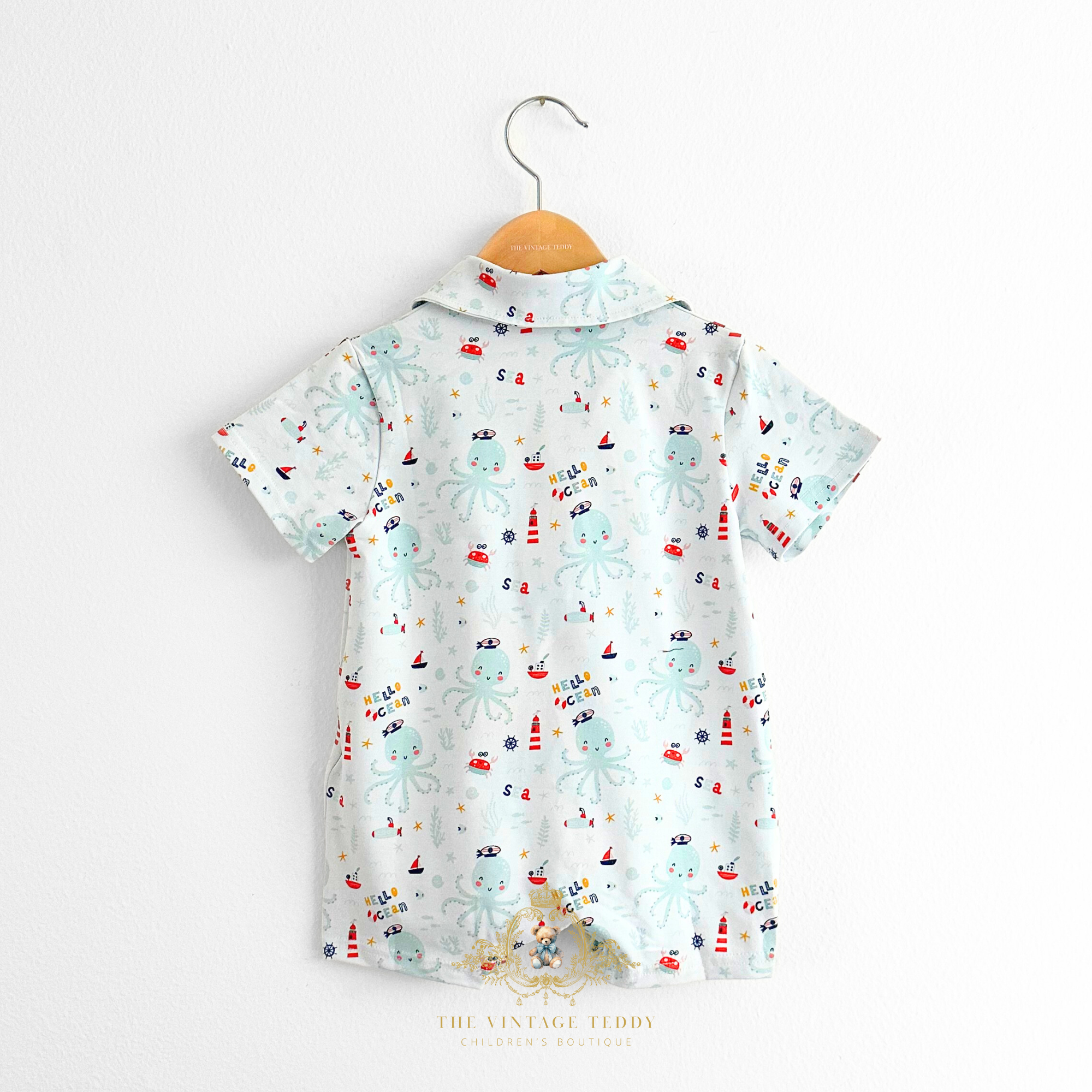 Baby & Toddlers oxford one-piece romper with a pattern of ocean & octopus hanging on a hanger on white background The Vintage Teddy Children's Boutique Cute Baby & Toddler Clothes for Kids