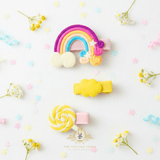 Yellow rainbow and lollipop hair clips for girls – flat lay mockup of children's hair accessories from The Vintage Teddy boutique