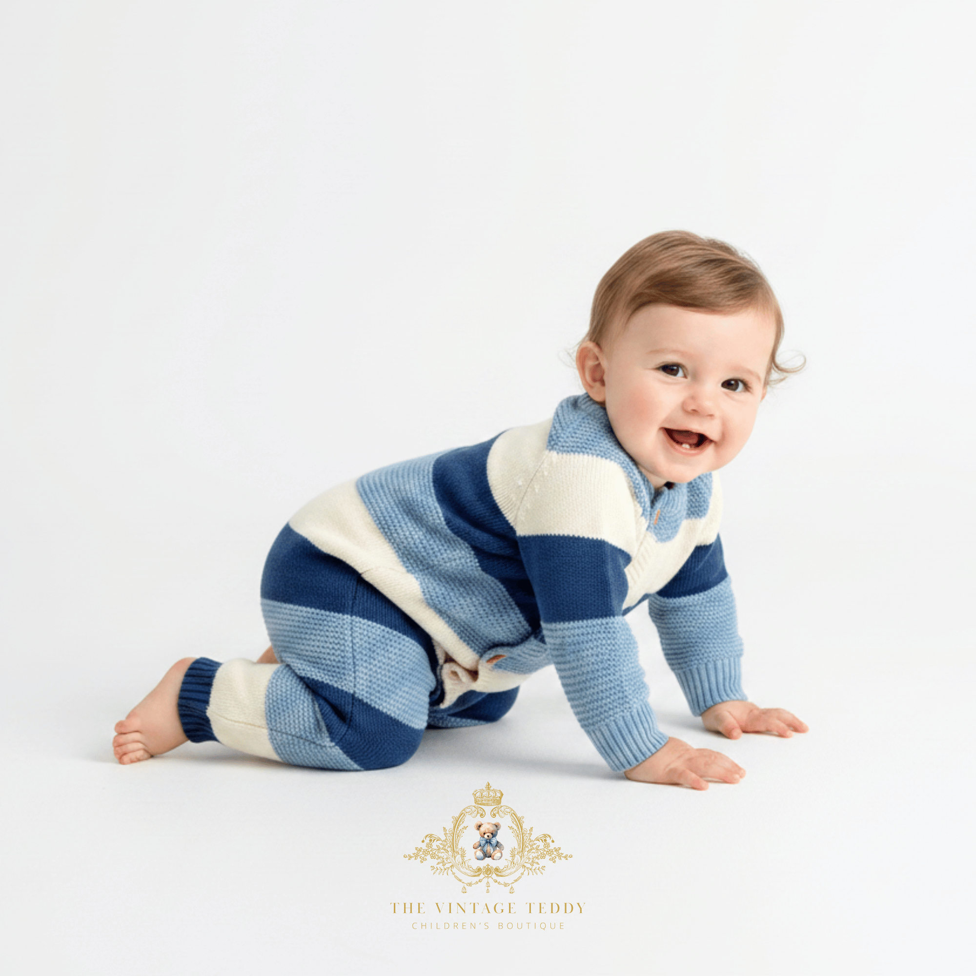 A baby boy crawling on a white studio floor wearing a two-toned blue and white striped knit romper. The brand watermark logo 'The Vintage Teddy' is visible at the bottom center.