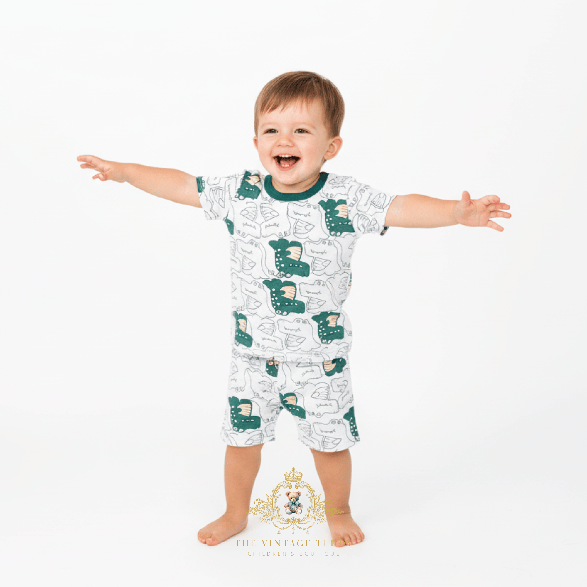Smiling toddler boy in white and green alligator t-shirt and shorts set children's boutique clothes for kids