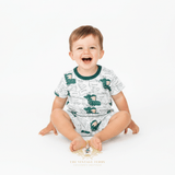 Toddler boy sitting wearing white and green alligator matching set boys cute kids clothes boutique outfit