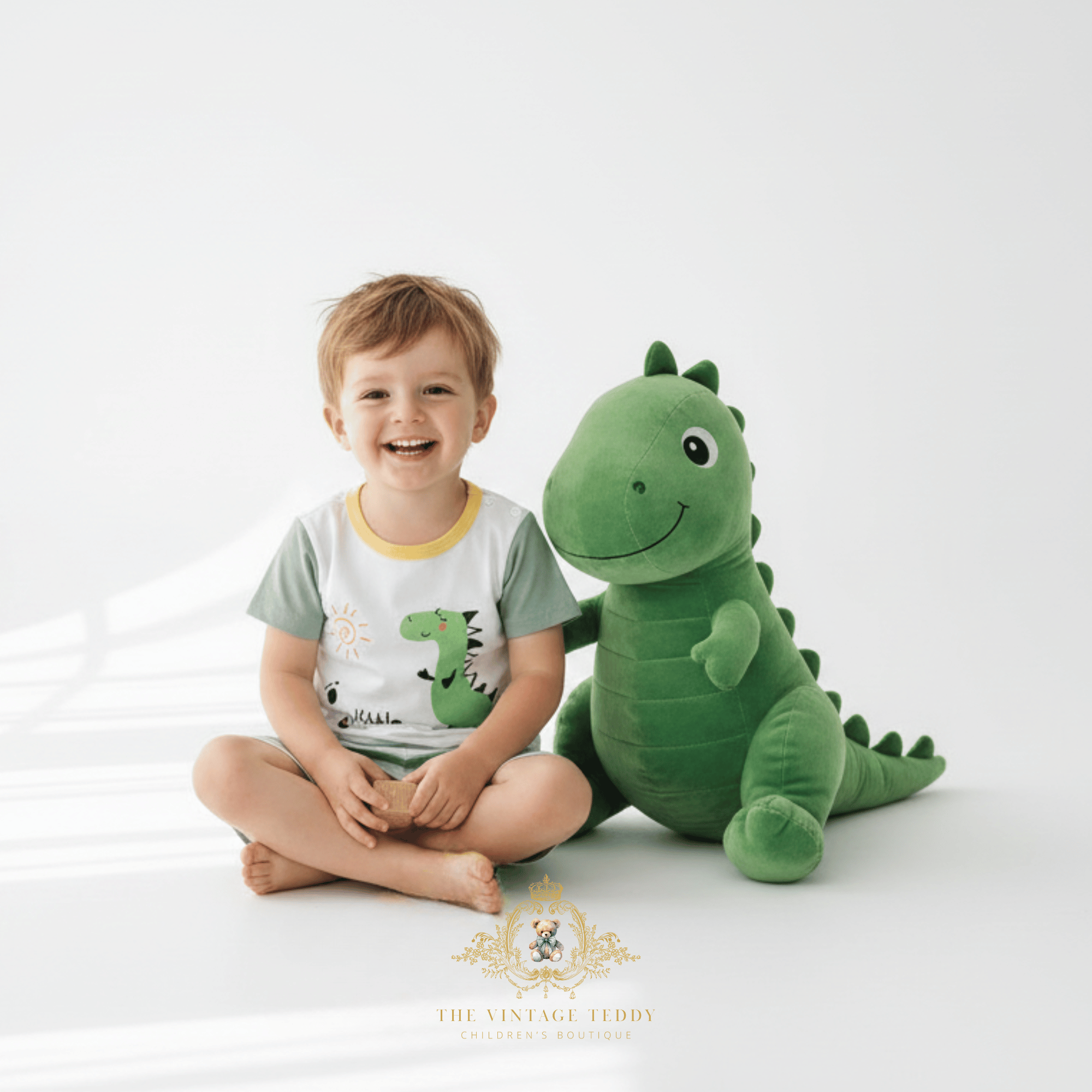 Toddler wearing Little Dino 2-piece matching set for boys summer outfit, kids clothes, sitting with dinosaurs plush toy