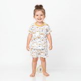 Toddler girl wearing Mr. Duck graphic t-shirt and shorts with all over print kids matching set yellow blue white kids clothes