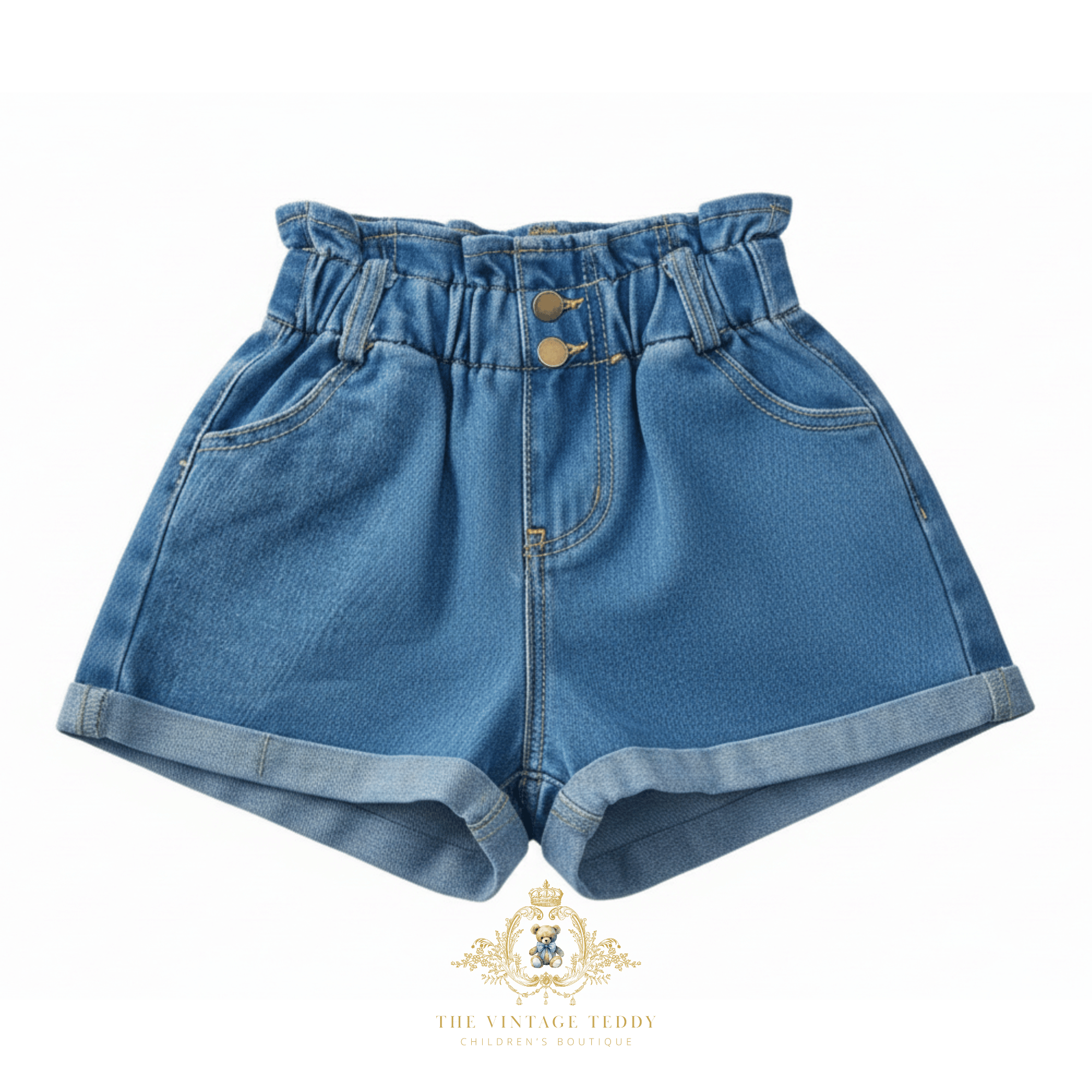 A pair of girls high-waisted blue denim shorts for kids with button closure, and rolled cuffs, shown against a plain white background with a brand watermark at the bottom.