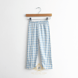 Little boys blue and white checkered long  pants with an elastic waistband hanging from a wooden hanger against a plain white wall.