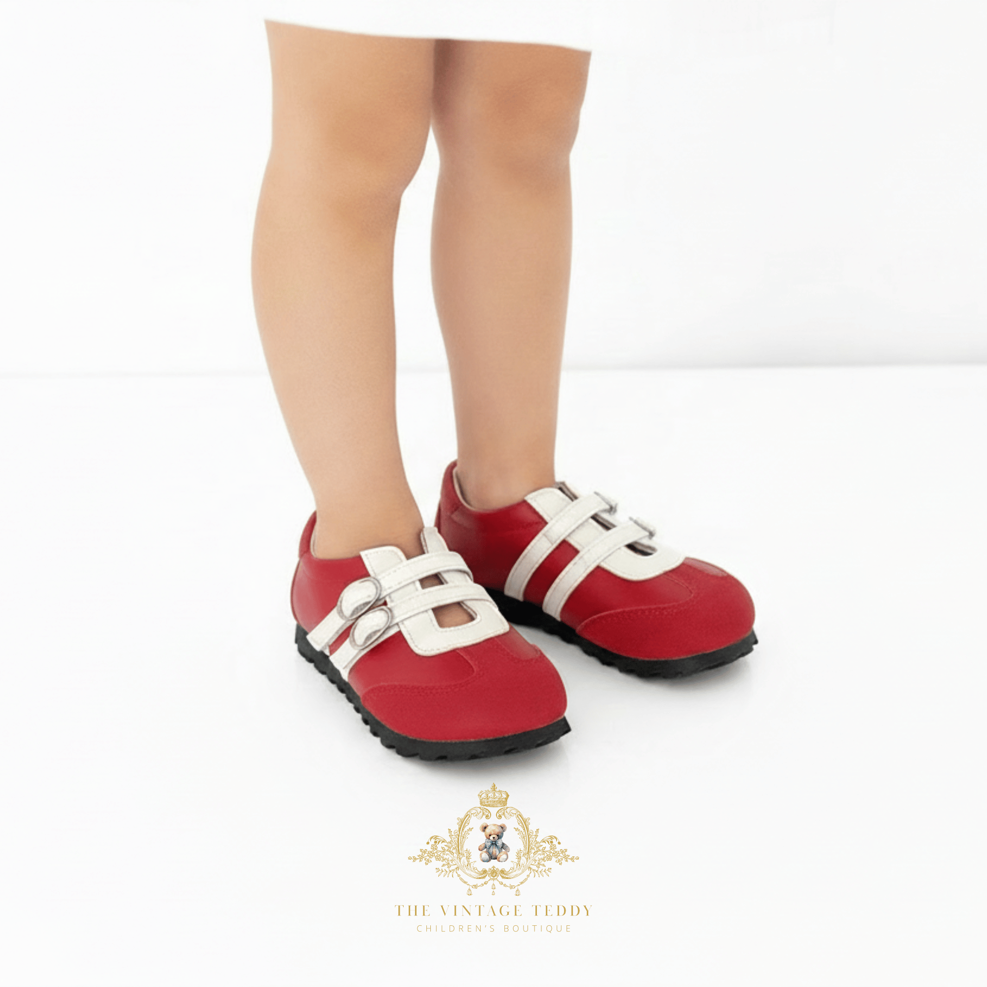 A child wearing red slip-on shoes with white strap details and black soles, shown from the knees down against a clean white background. A 'The Vintage Teddy' brand logo is visible at the bottom.