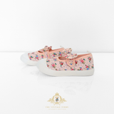 Pair of pink floral kids sneakers with white soles and pretty bow on a light background, displayed side by side.