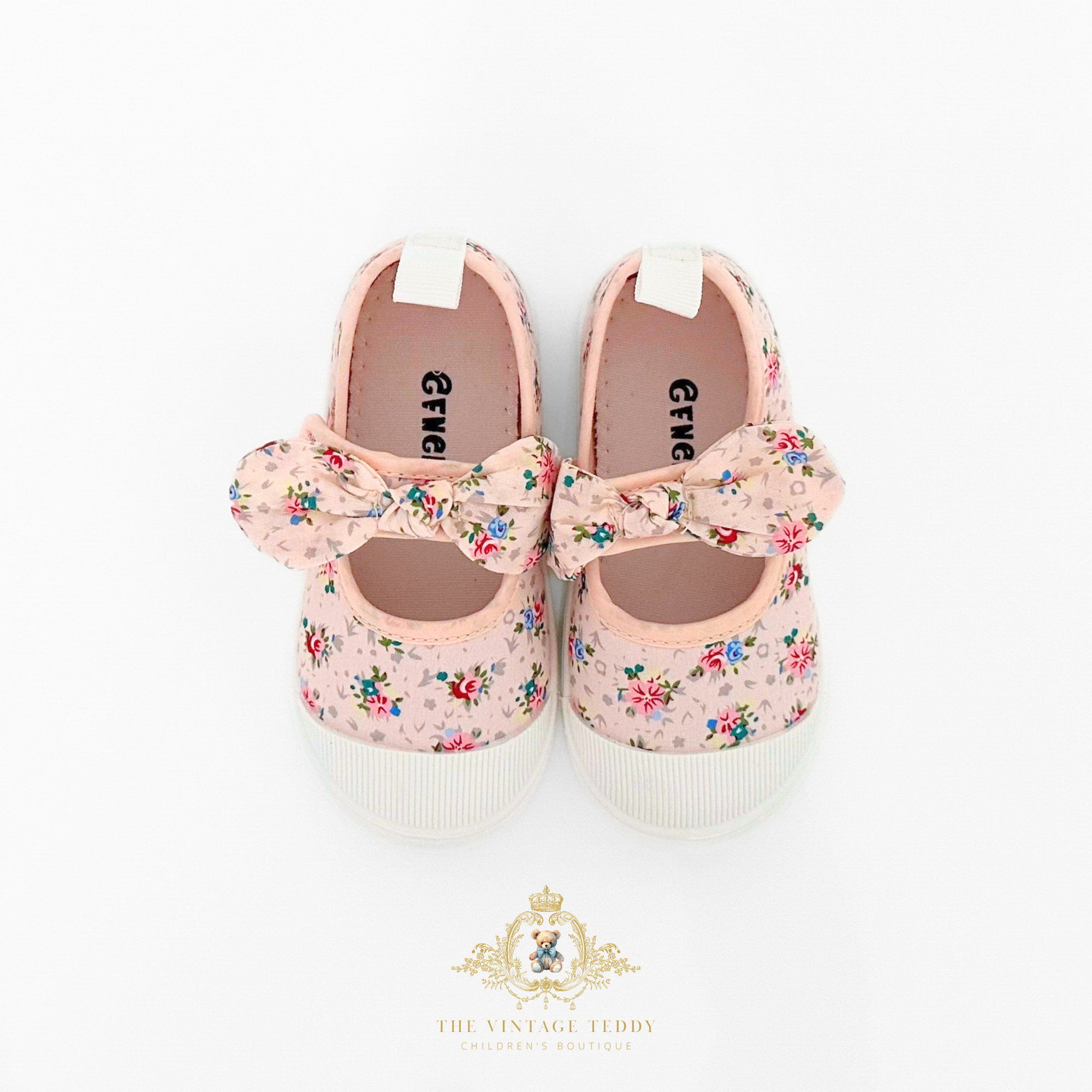 Top view of floral patterned kids shoes with bows on a white background, featuring the brand logo 'The Vintage Teddy'.
