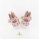 Top view of a pair of pink floral girls shoes for kids with white soles on a light background, featuring the 'The Vintage Teddy' brand logo.