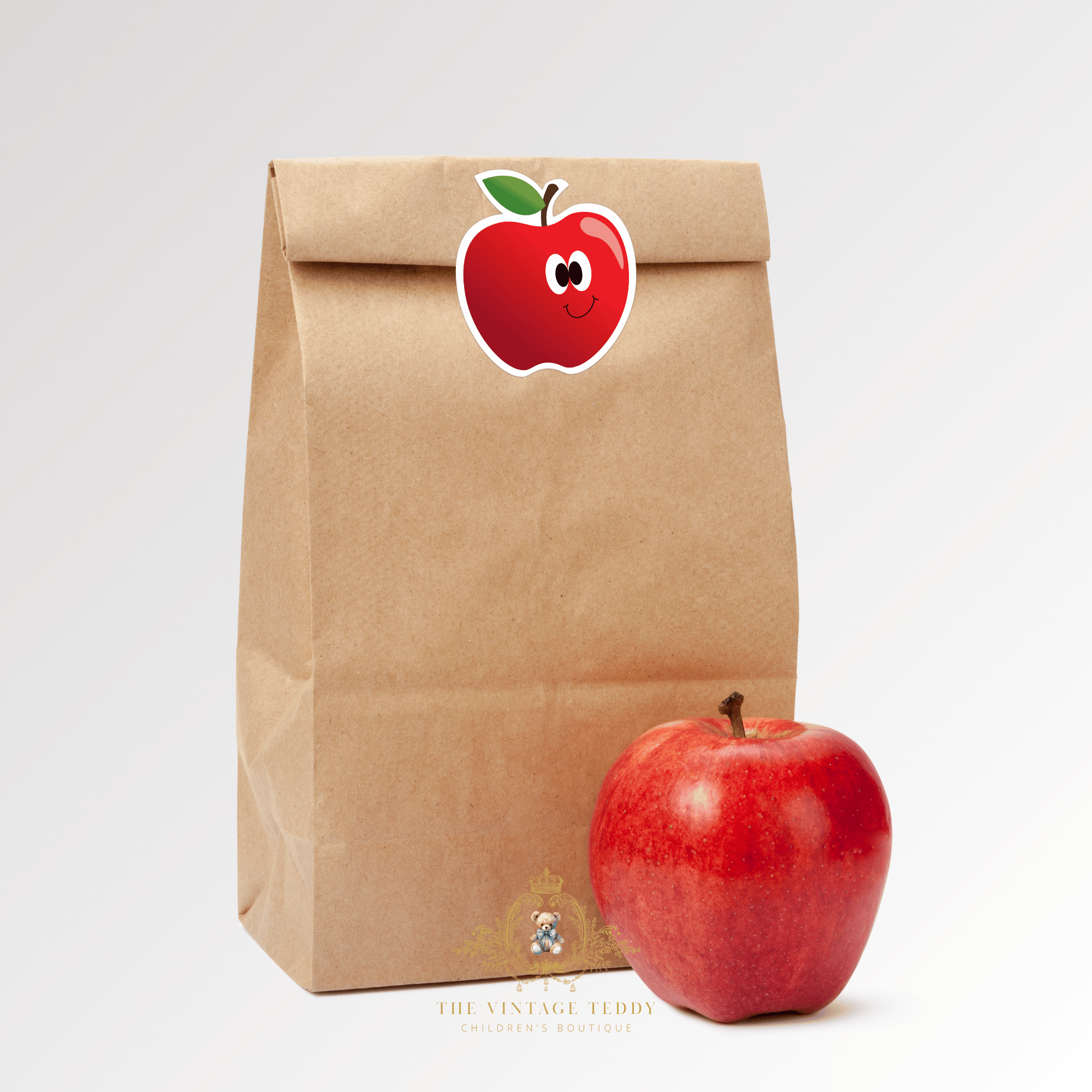 Brown paper bag with a red apple sticker and a real red apple on a white background cute stickers for kids